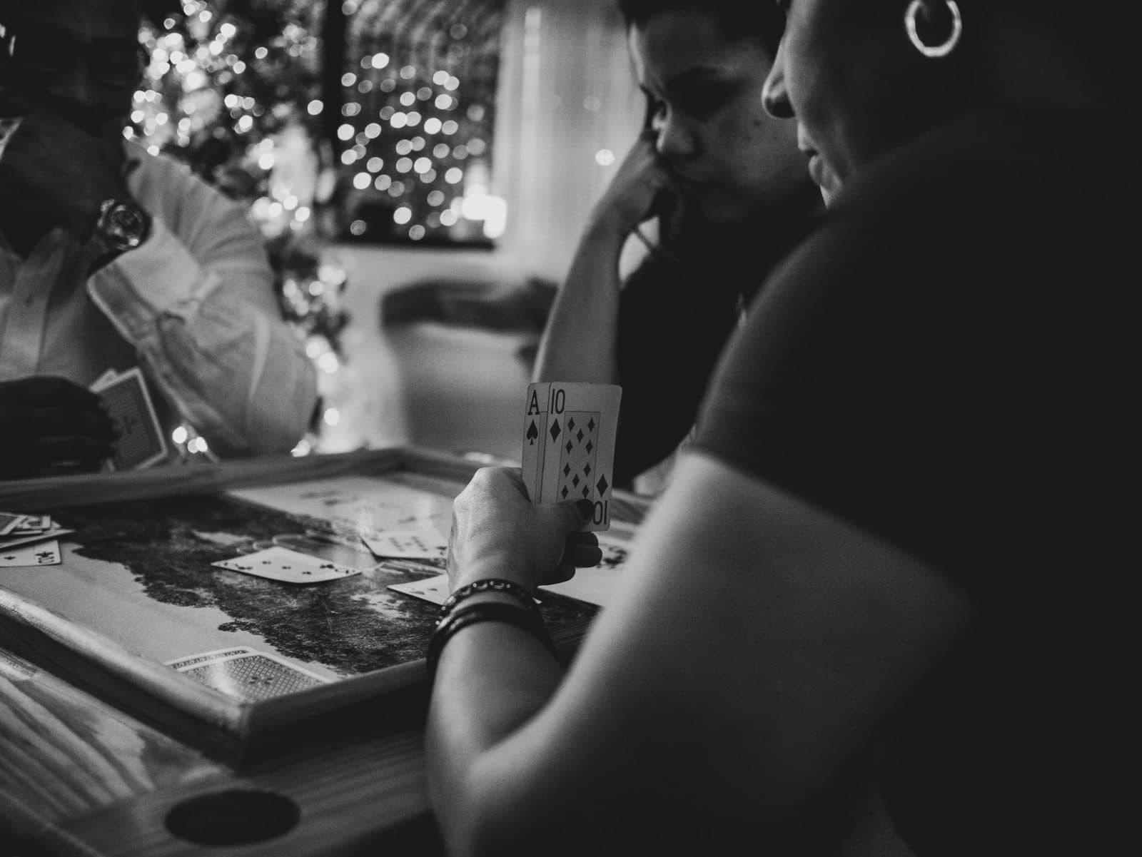 A group of people sitting around a table playing cards together