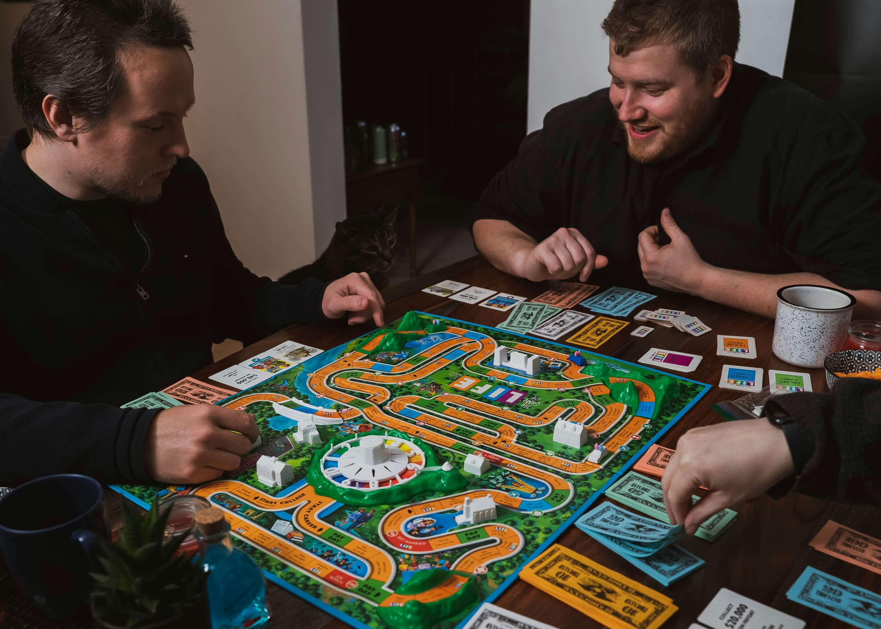 Two people playing a game of Monopoly on a table